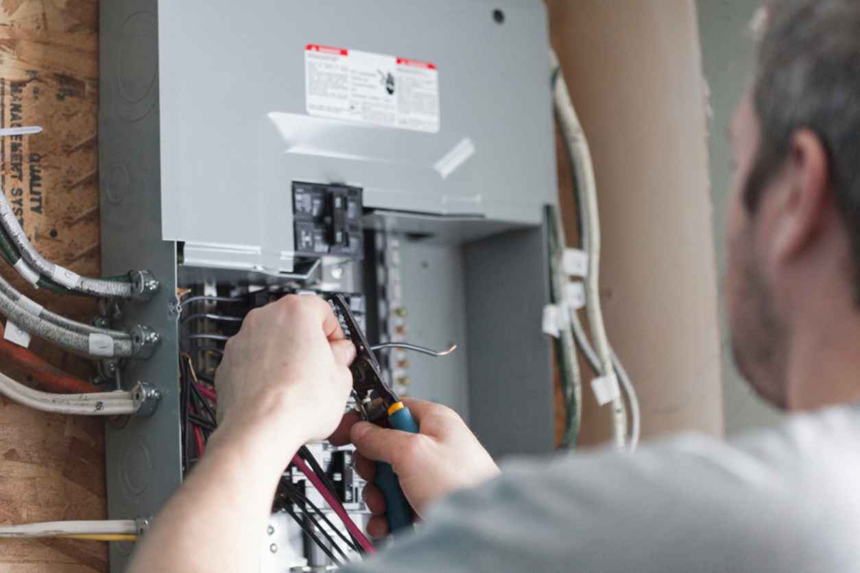 Electrician replacing the distribution board to upgrade a home's electrical panel.