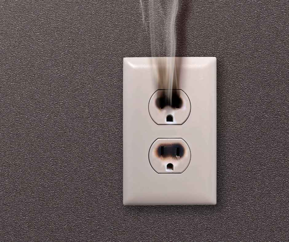 A smoking electrical outlet that is on fire