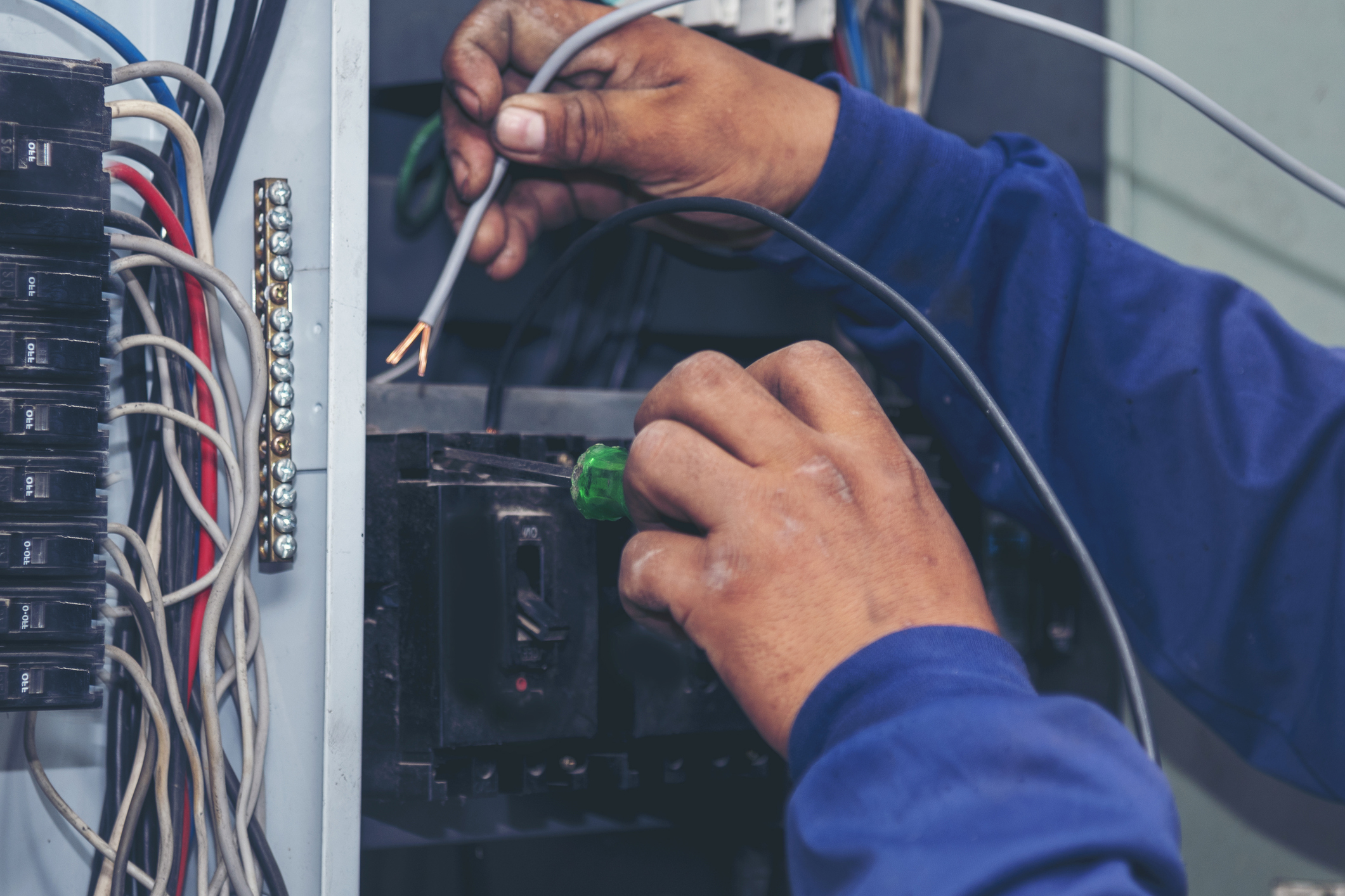 An electrician upgrading an electrical panel and repairing wiring