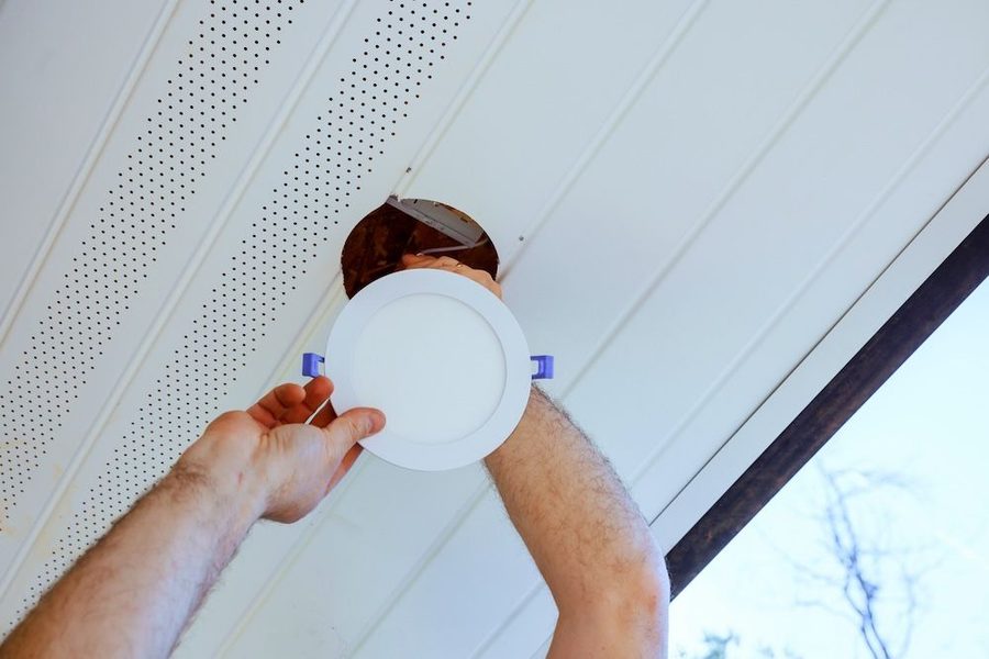 Electrician installing recessed LED lighting in a ceiling