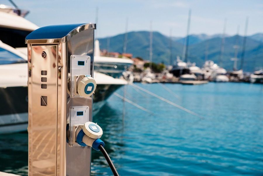Pier power installation by the dock with water and boats in the background