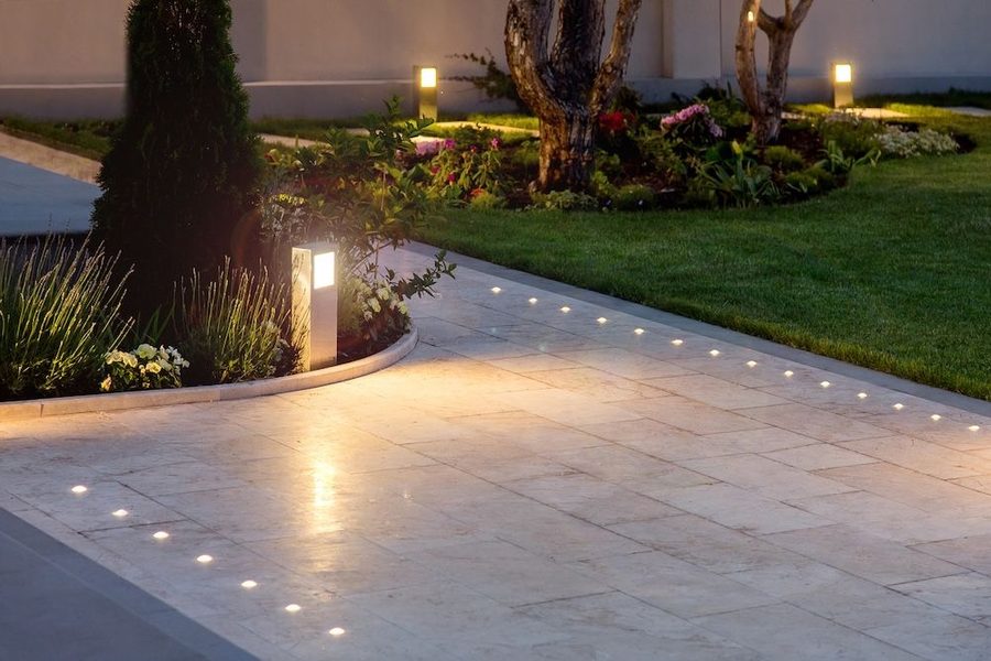 Outdoor pathway lit up with landscape lighting outside of a home