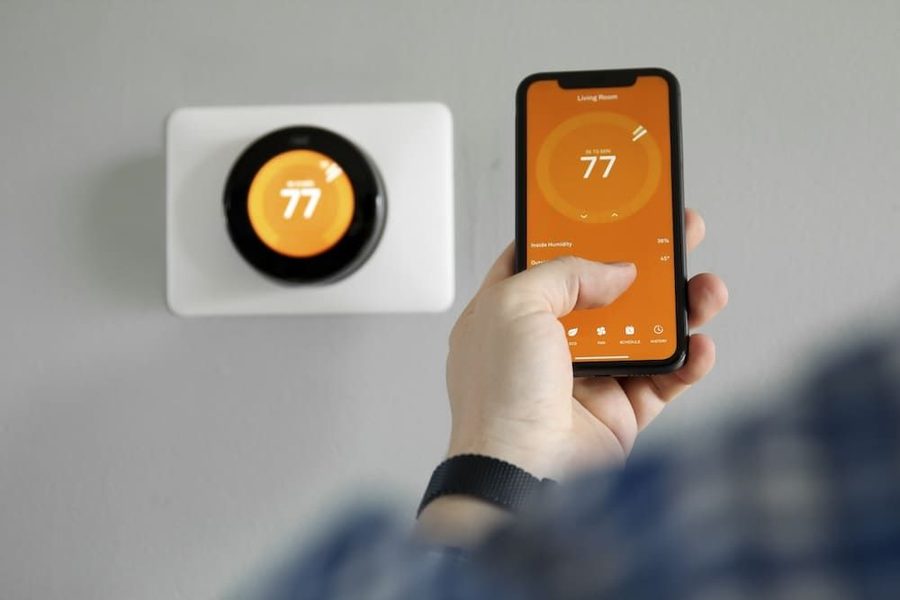Homeowner controlling the temperature on their smart thermostat from their phone